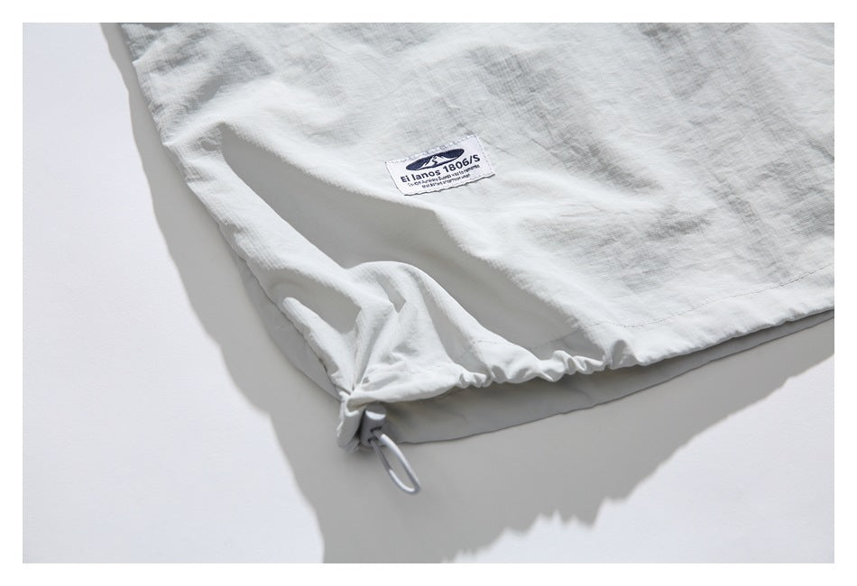 Close-up of the pullover's lower hem with an adjustable drawcord and sewn label.