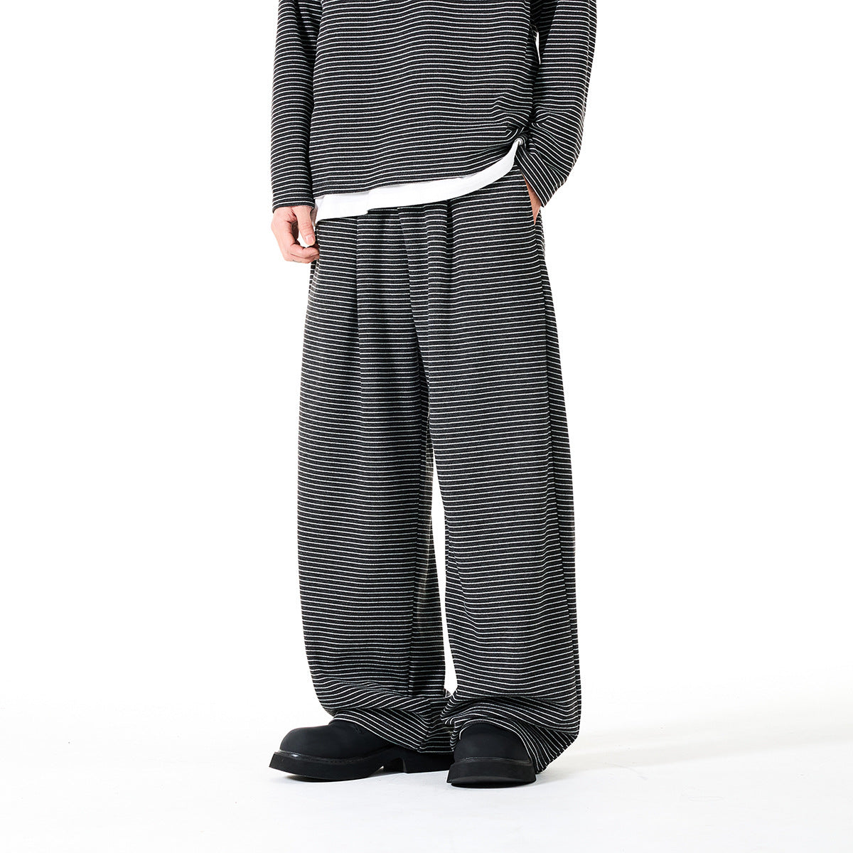 Front view of a model wearing dark wide-leg pants with thin white horizontal stripes and a matching top.
