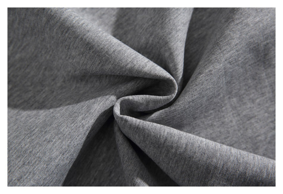 Close-up of heather gray knit fabric gathered into soft folds, showing its fine texture.
