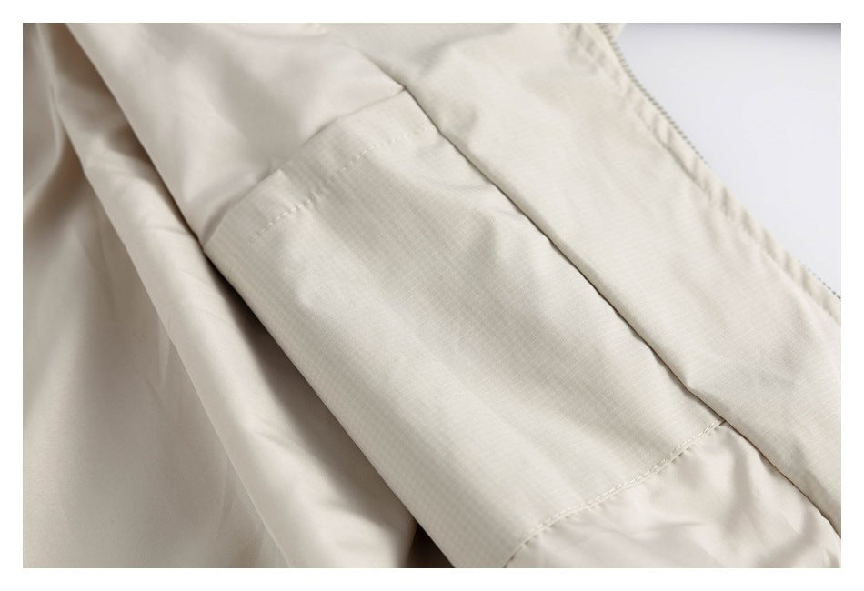 Close-up of a stitched rectangular panel on the cream jacket.