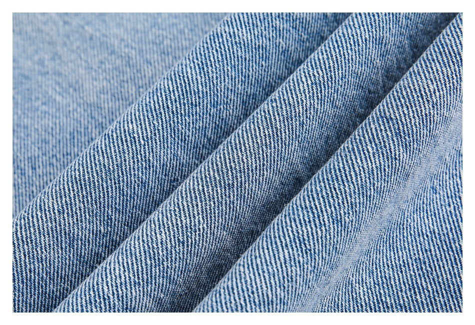 Extreme close-up of folded blue denim showing its diagonal twill weave.