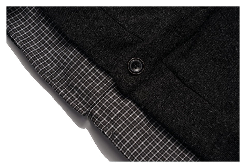 Close-up showing a black button on charcoal fabric beside a black-and-white checked lining.