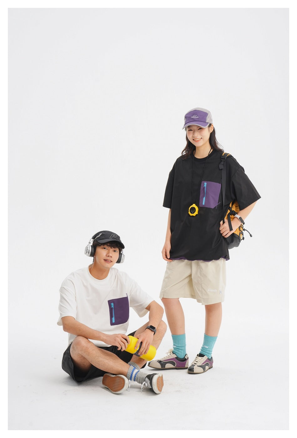 Two models wear oversized black and white tees with purple zip chest pockets; the black tee has purple hem trim.