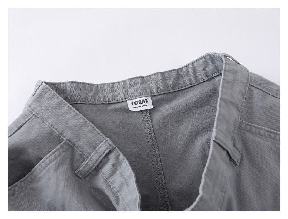 Close-up of gray shorts showing the inside waistband, seams and a sewn-in brand label.