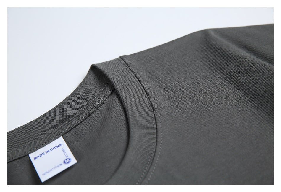 Angled close-up of the charcoal T-shirt's ribbed collar, stitching, and partially visible inner label.