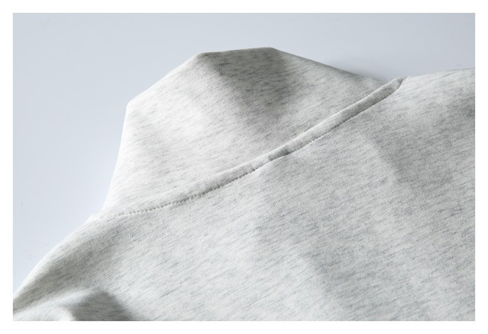 Close-up of a seam on pale heather gray knit fabric.