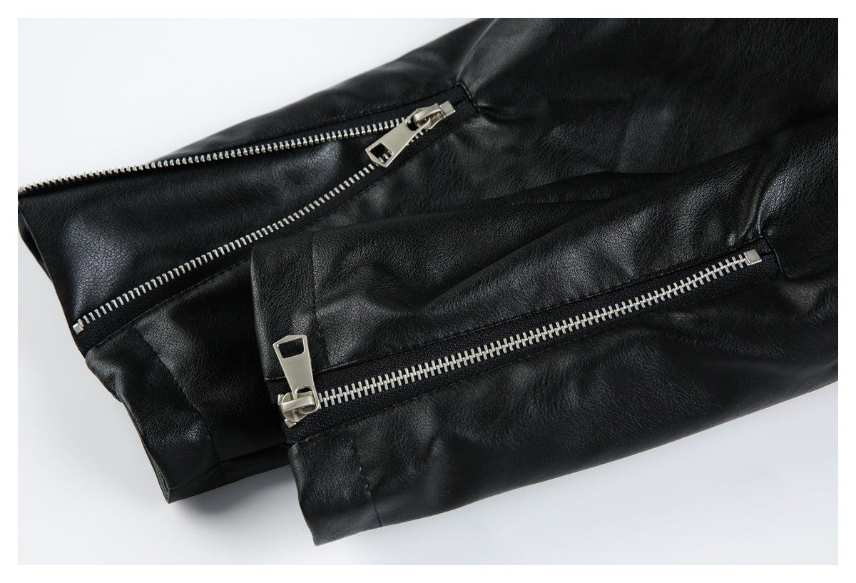 Close-up of a black jacket sleeve with two silver zippers and stitched panels.