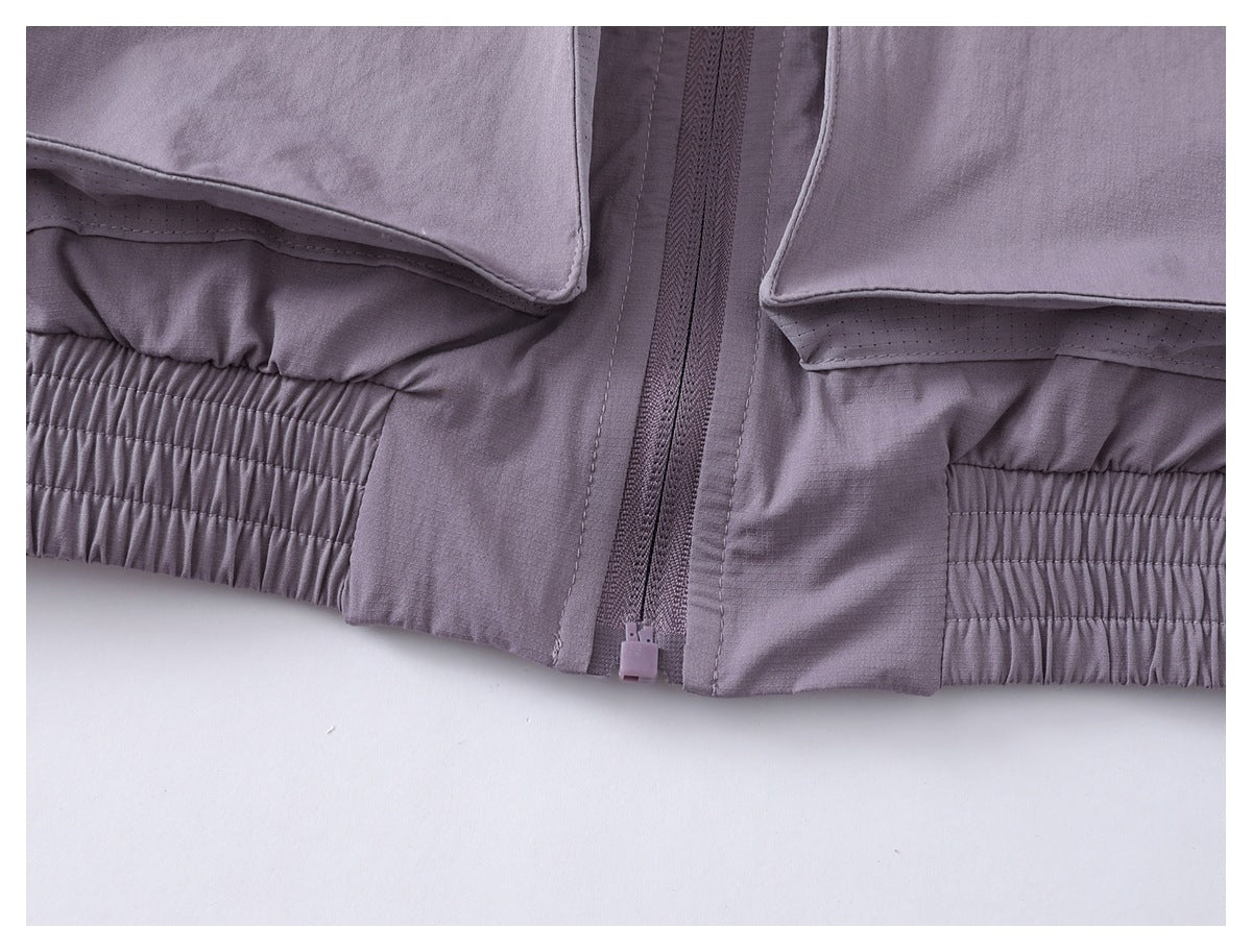 Close-up of the lavender jacket's center zipper and gathered elastic hem.
