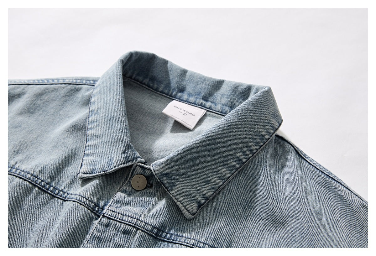 Close-up of a light blue washed denim jacket collar, button, and inner label reading “Made in China.”