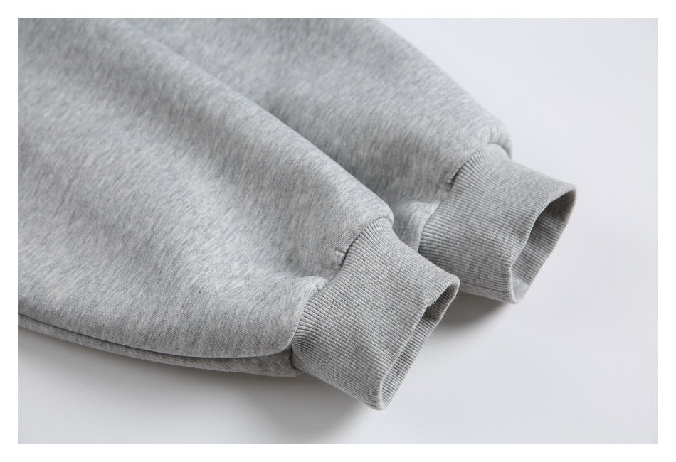 Close-up of two gray heather sleeves ending in wide ribbed cuffs.