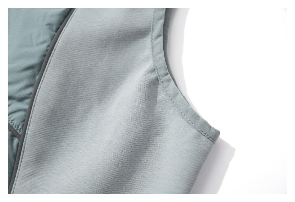 Close-up of pale blue-gray garment panel with curved stitched edge and darker piping.