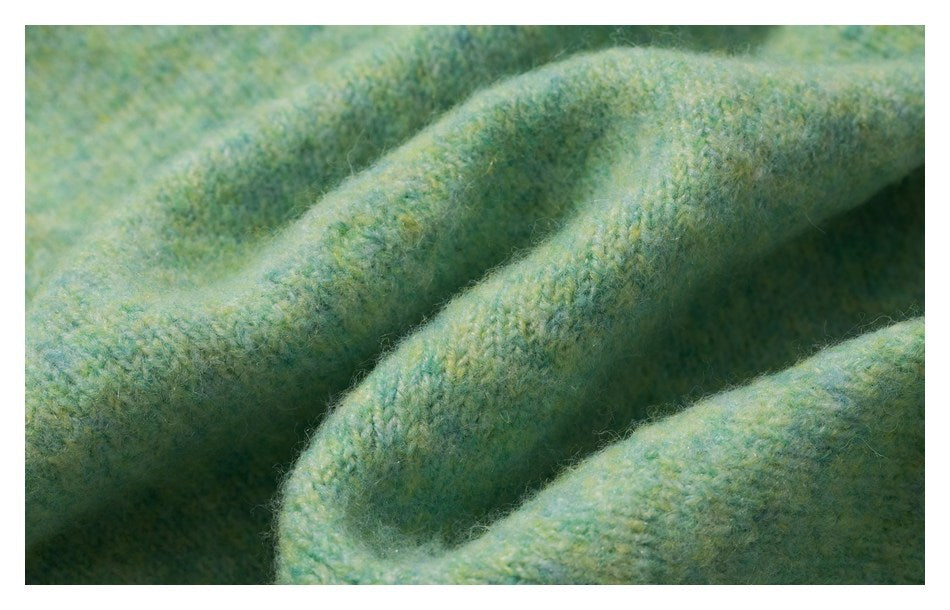 Macro view of the fuzzy, mottled mint-green knit texture and folded fabric.