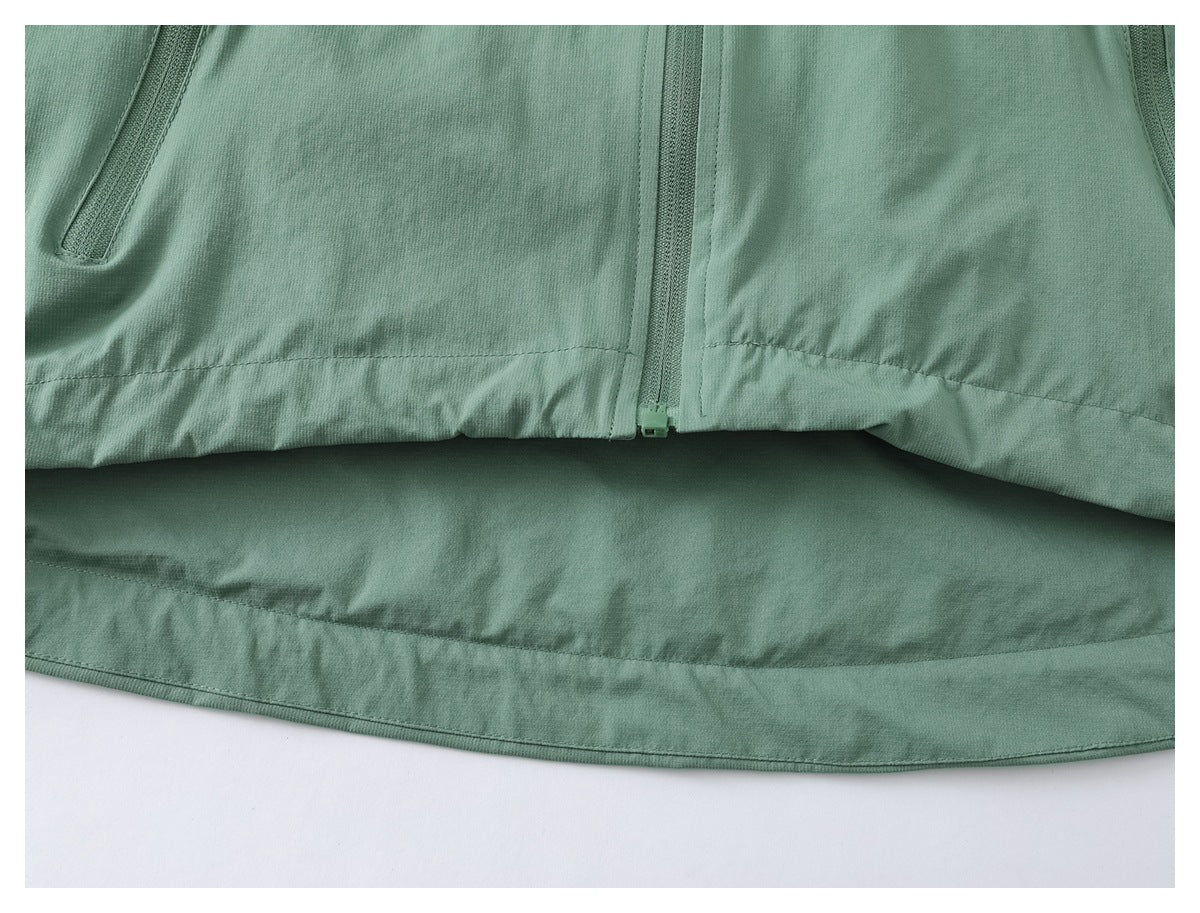 Close-up of the sage green jacket's front zipper, lower hem, and side pocket openings.