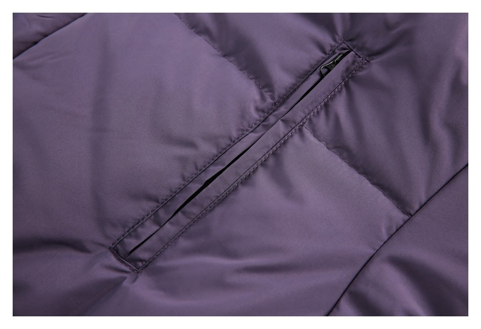 Close-up of a diagonal black zip pocket on a purple garment.