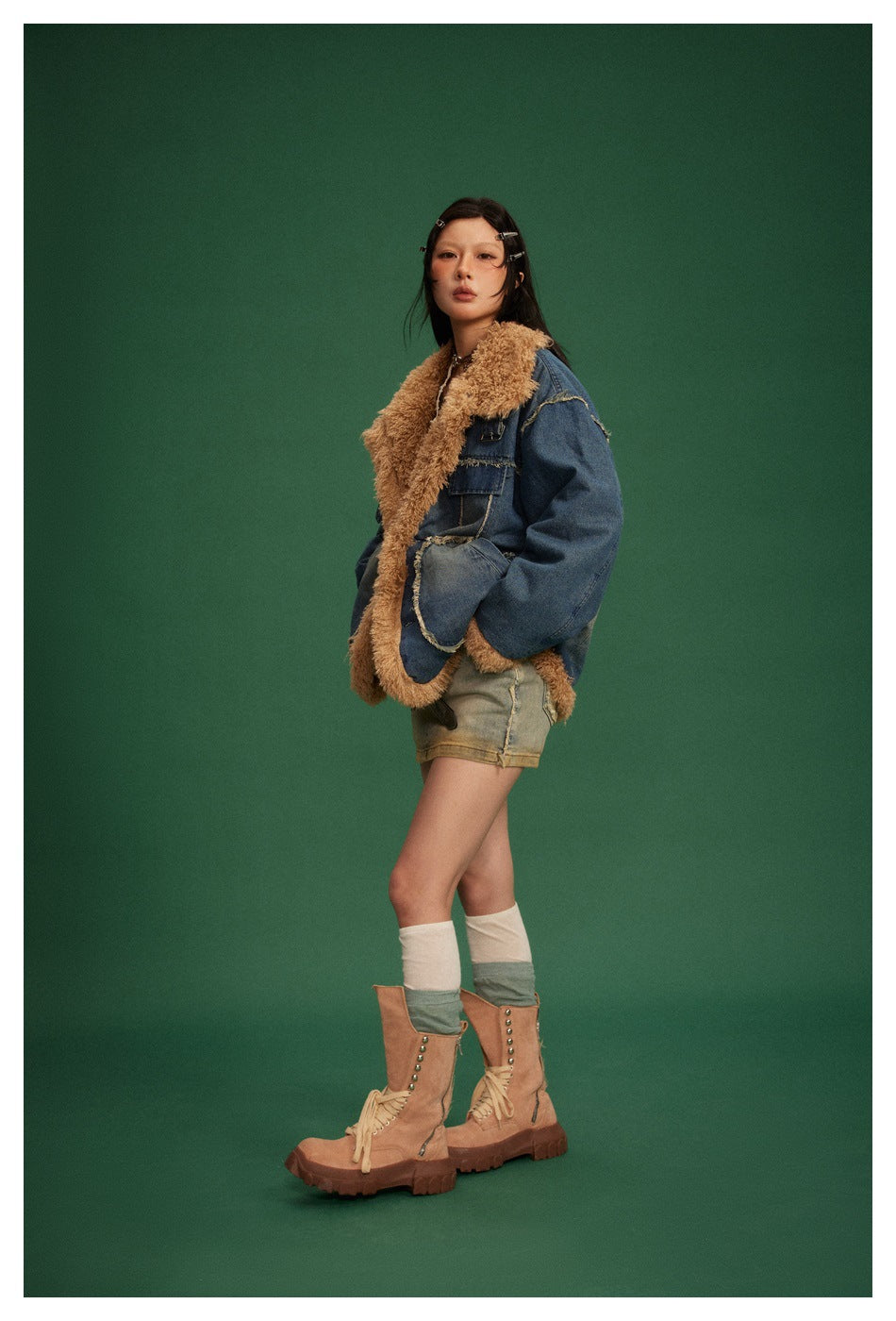 Full-length side view of a model in a blue denim jacket with tan shaggy trim and large pockets.