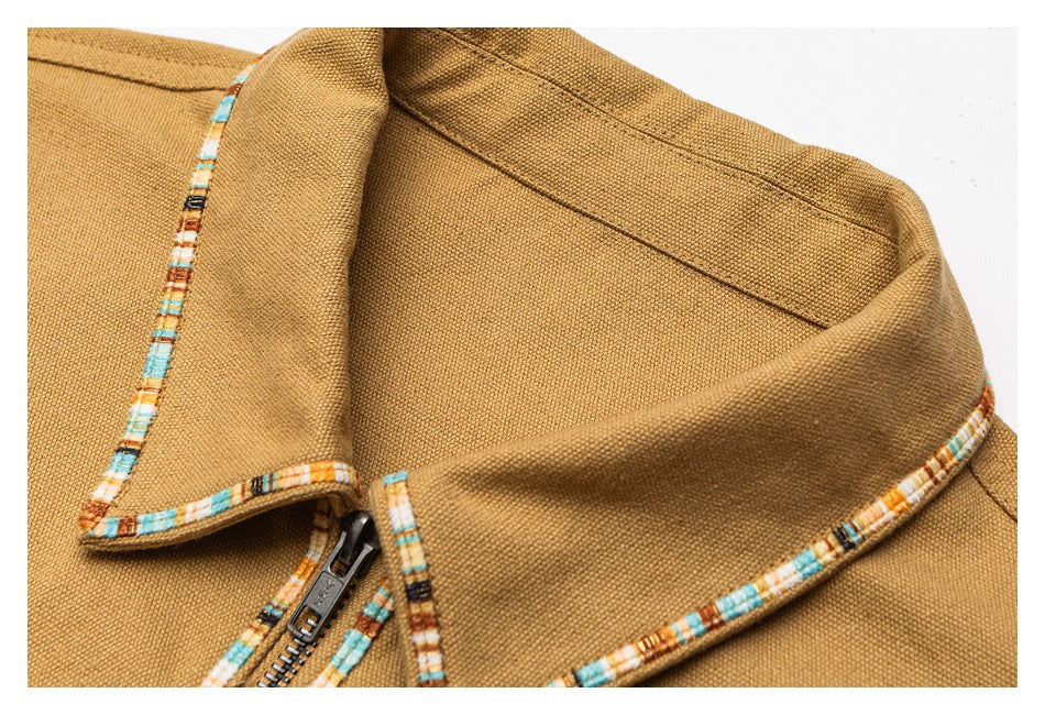 Close-up of a tan jacket collar with multicolor patterned trim and part of the front zipper.