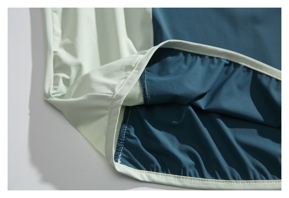Close-up of the garment's interior, showing teal and pale mint panels, seams, and finished edges.