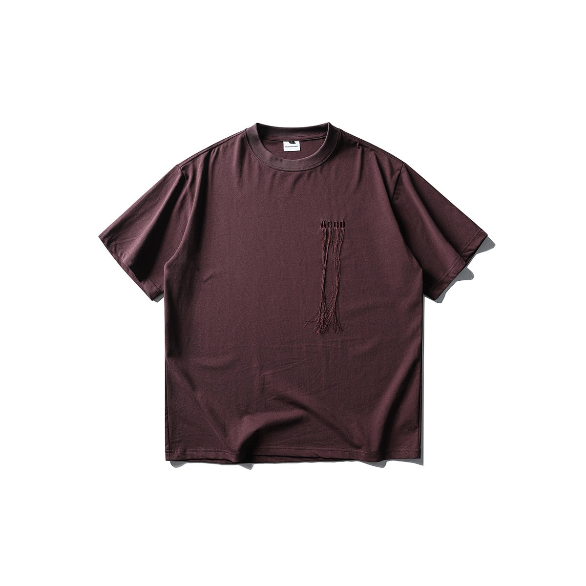 Burgundy short-sleeve crew-neck T-shirt flat lay with embroidered ABCD lettering and thread fringe on the chest