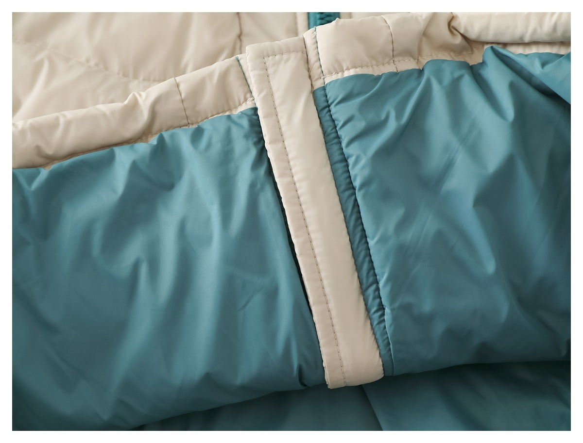 Close-up of the teal lining and cream zipper flap inside a quilted jacket.