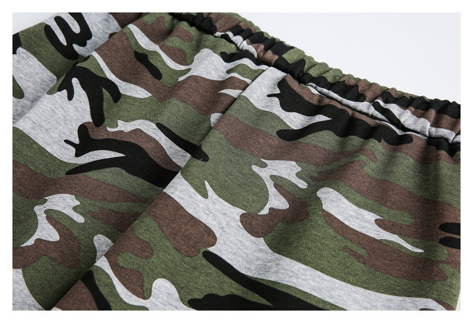 Close-up of green, brown, gray, and black camouflage pants showing the gathered elastic waistband.