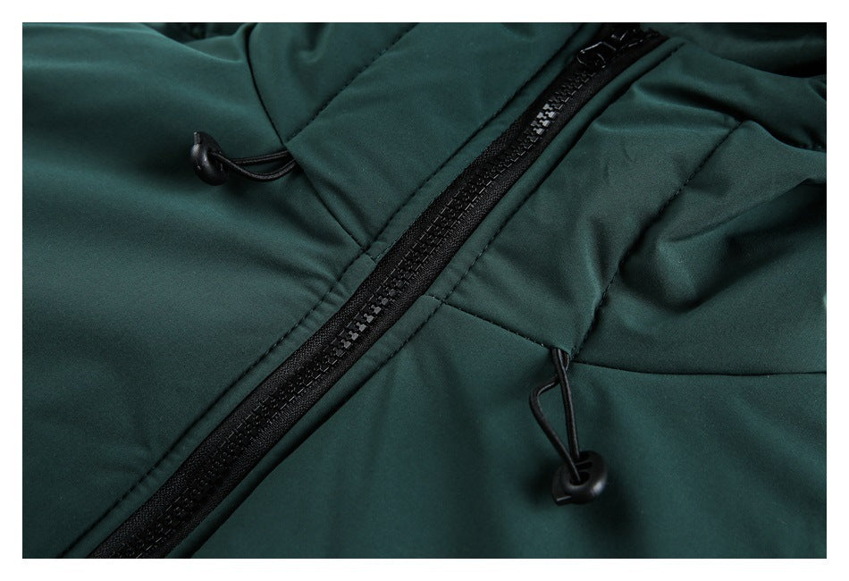Close-up of a dark green jacket’s black zipper and adjustable drawcord toggles.
