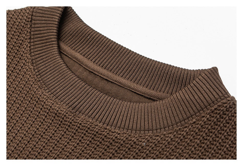 Close-up of the brown sweater's ribbed crew neckline and textured knit body.