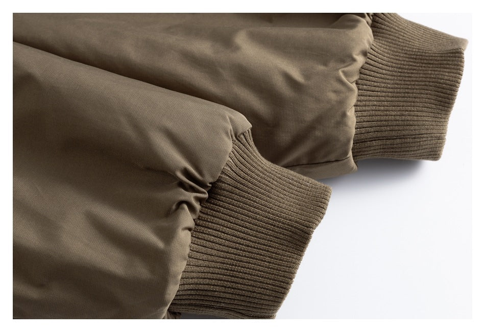 Close-up of two taupe-brown jacket sleeves with wide ribbed cuffs.