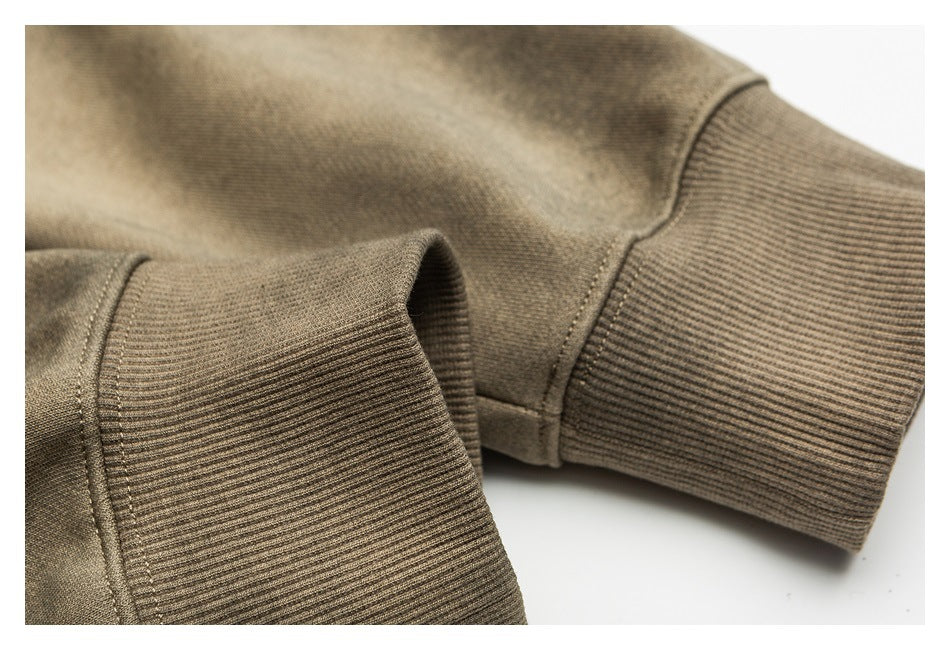 Close-up of ribbed cuffs and stitching on a tan-brown mottled sweatshirt sleeve.