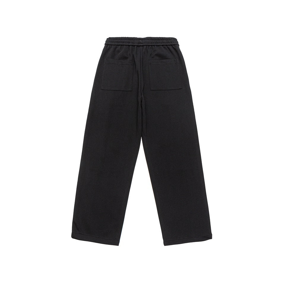 Back view of black wide-leg trousers with an elastic waistband and two patch pockets.
