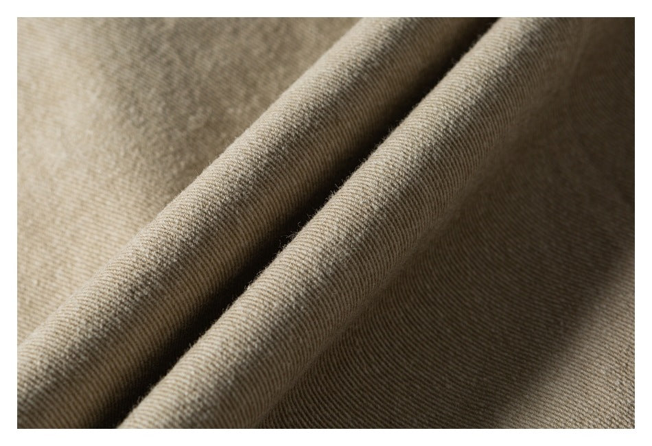 Close-up of folded taupe-beige fabric showing its fine diagonal weave.