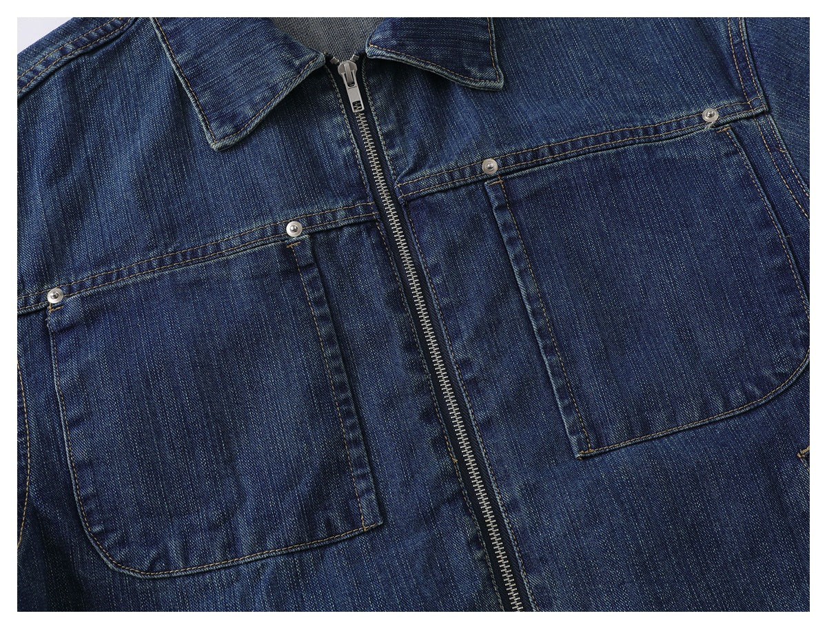 Close-up of the jacket front showing a metal zipper, pointed collar, and two large rivet-trimmed patch pockets.