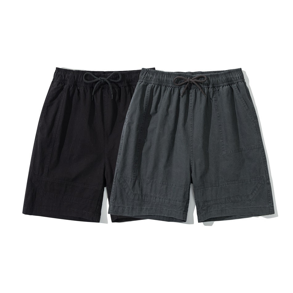 Two pairs of drawstring shorts shown from the front in black and charcoal gray, with angled pockets and stitched hems.