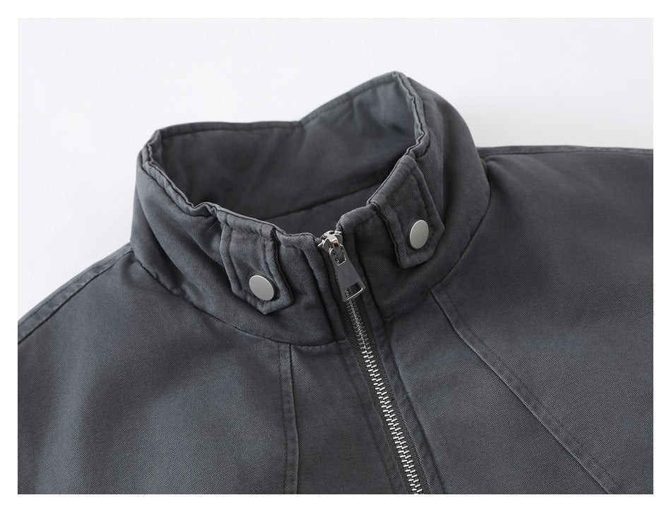 Close-up of the charcoal jacket's stand collar, snap-tab details, and front zipper.