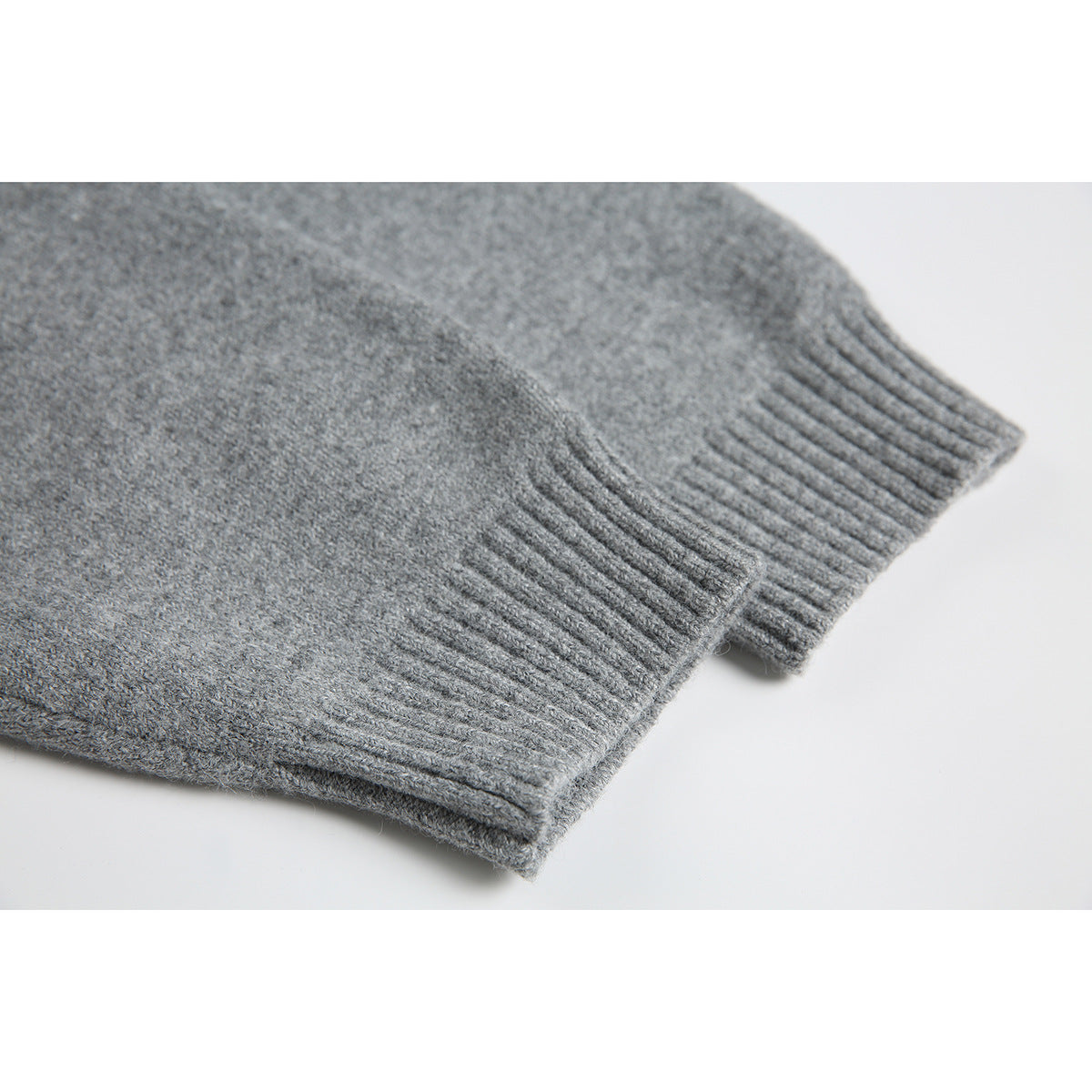 Close-up of a gray sweater's ribbed cuff and knit texture.
