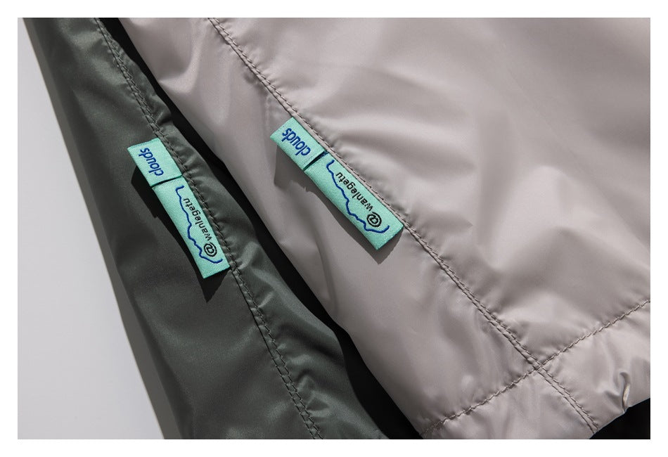 Close-up of pale taupe and dark olive garment panels, each with a turquoise woven label.