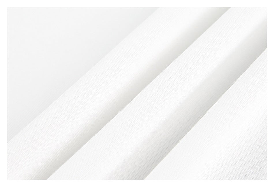 Close-up of white fabric arranged in soft folds, showing its fine surface texture.