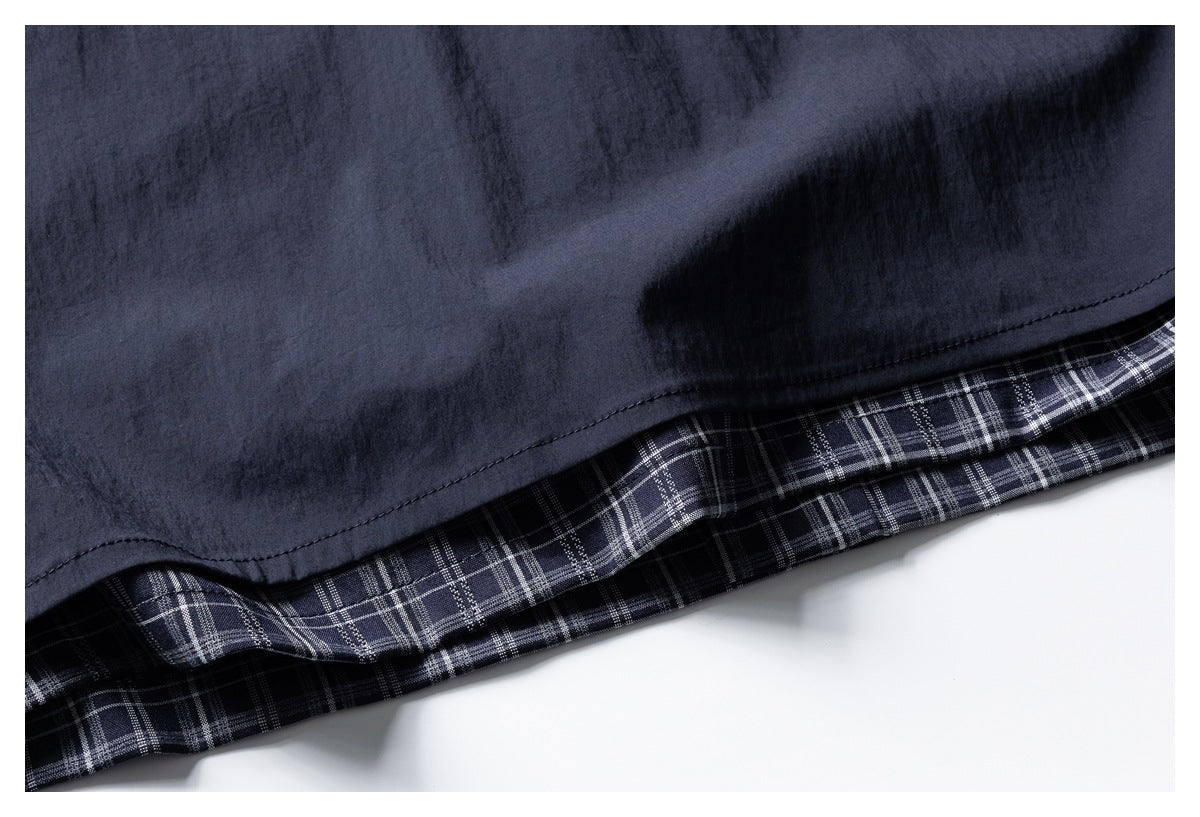 Close-up of a dark navy hem folded back to reveal navy-and-white plaid fabric underneath.