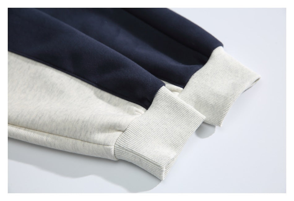 Close-up of ribbed light gray cuffs on navy and light gray sweatshirt sleeves.