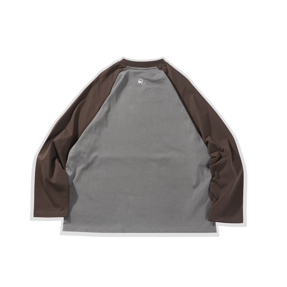 Back of a gray raglan long-sleeve shirt with dark brown sleeves and a small white graphic below the collar.