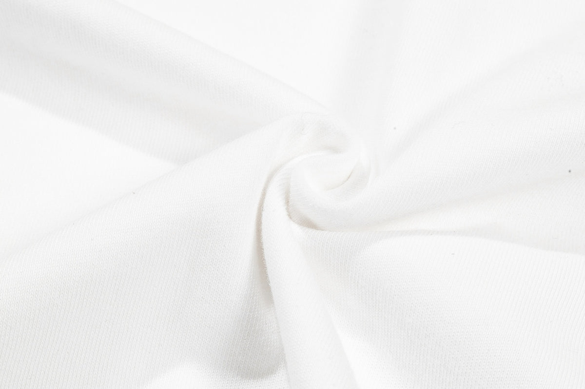Close-up of white fabric with a fine textured knit and gathered fold.