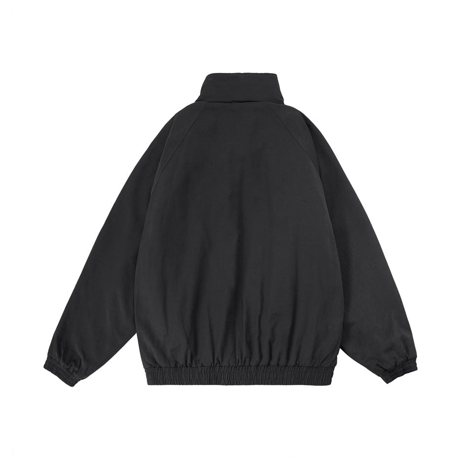 Back view of a black jacket with a high collar, raglan sleeves, and elasticated cuffs and hem.