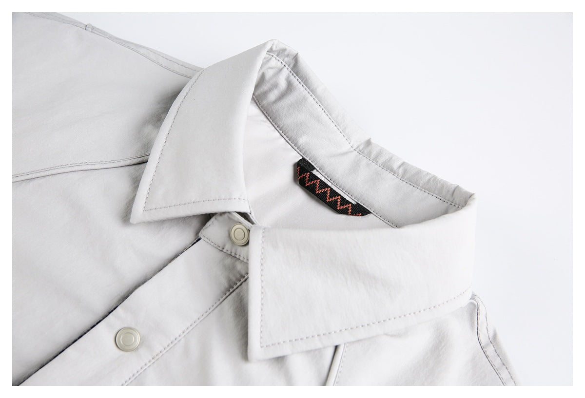 Close-up of the light gray jacket's wide collar, snap closure, and black neck trim with a red zigzag pattern.