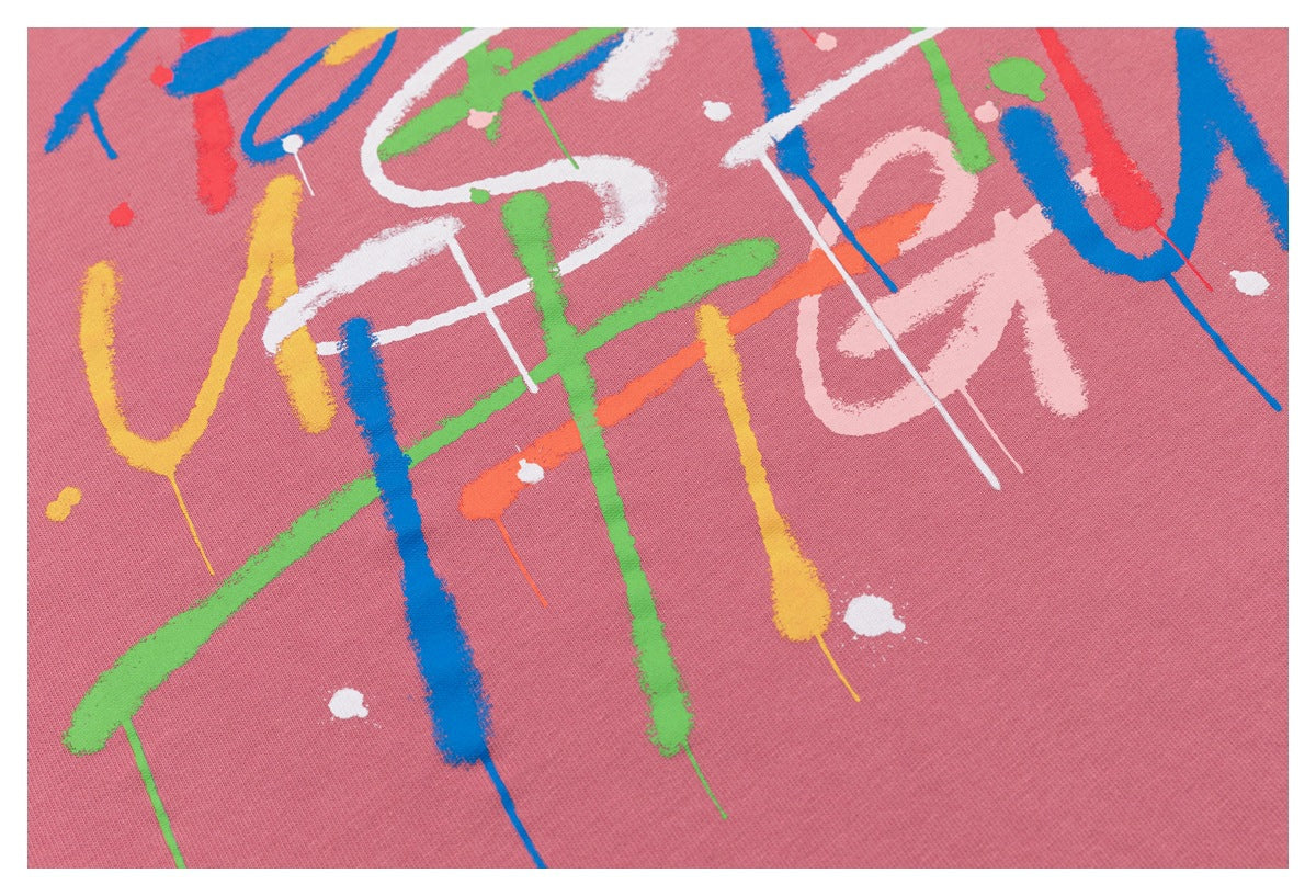 Close-up of the multicolored abstract brushstroke print across dusty rose sweatshirt fabric.