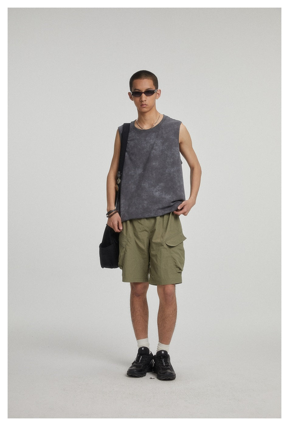 Full-length model wearing a charcoal mottled sleeveless top and olive cargo shorts.