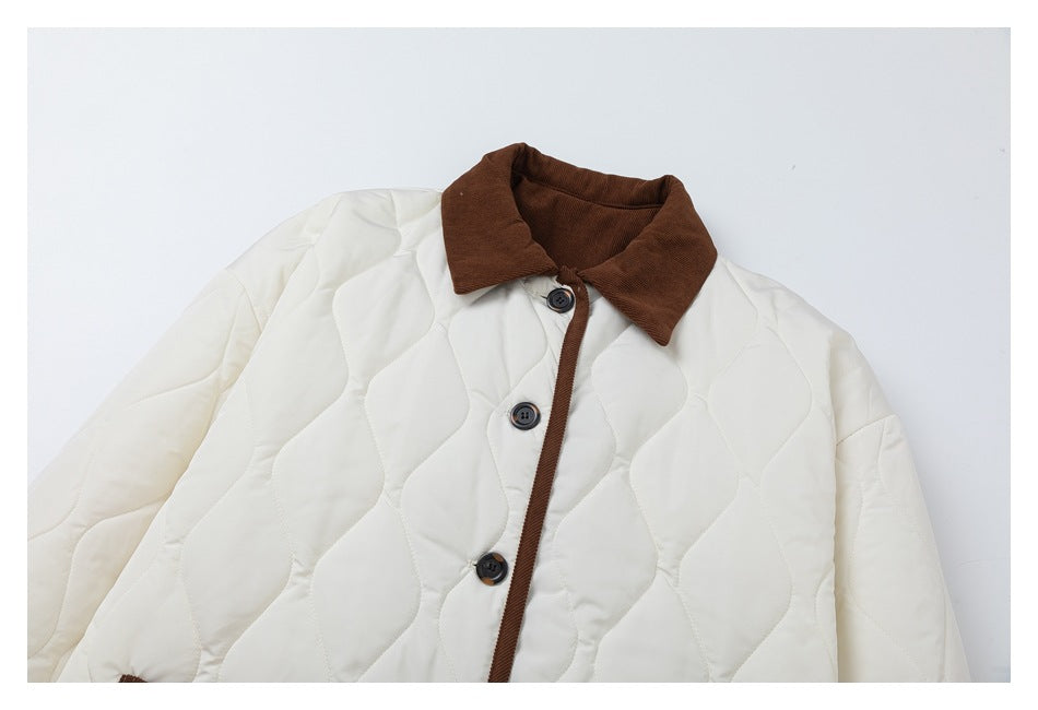 Cropped front view of an ivory quilted jacket with a brown corduroy collar, trim, and dark buttons.