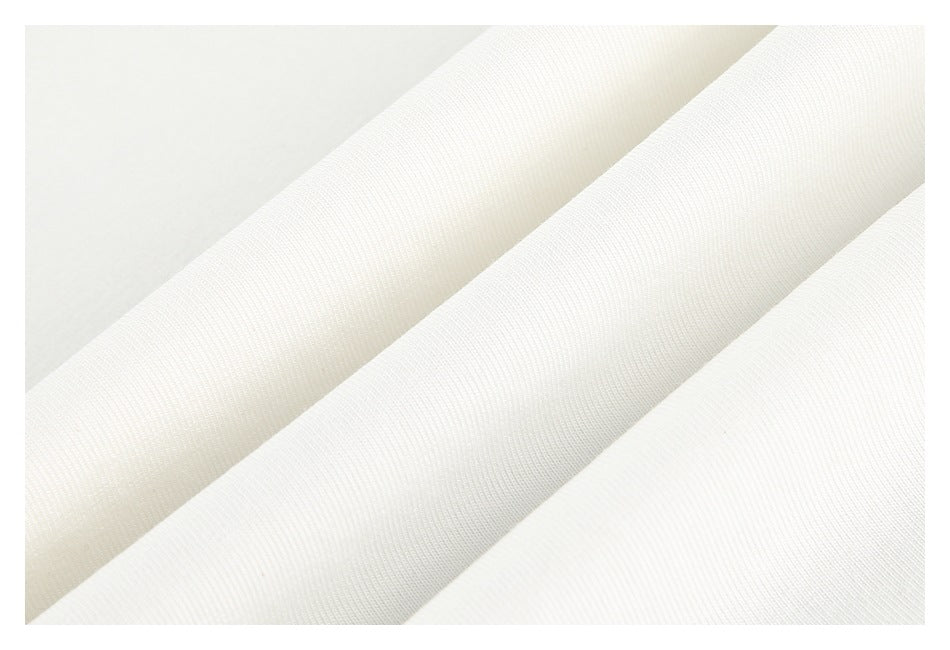 Close-up of off-white garment fabric arranged in soft diagonal folds.