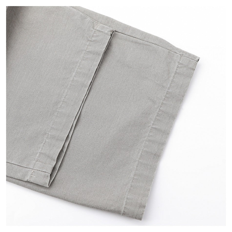 Close-up of a folded trouser leg hem and stitched seams on gray trousers.