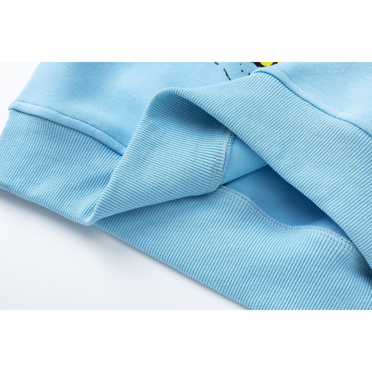 Close-up of the light blue sweatshirt's ribbed cuff and stitched hem.