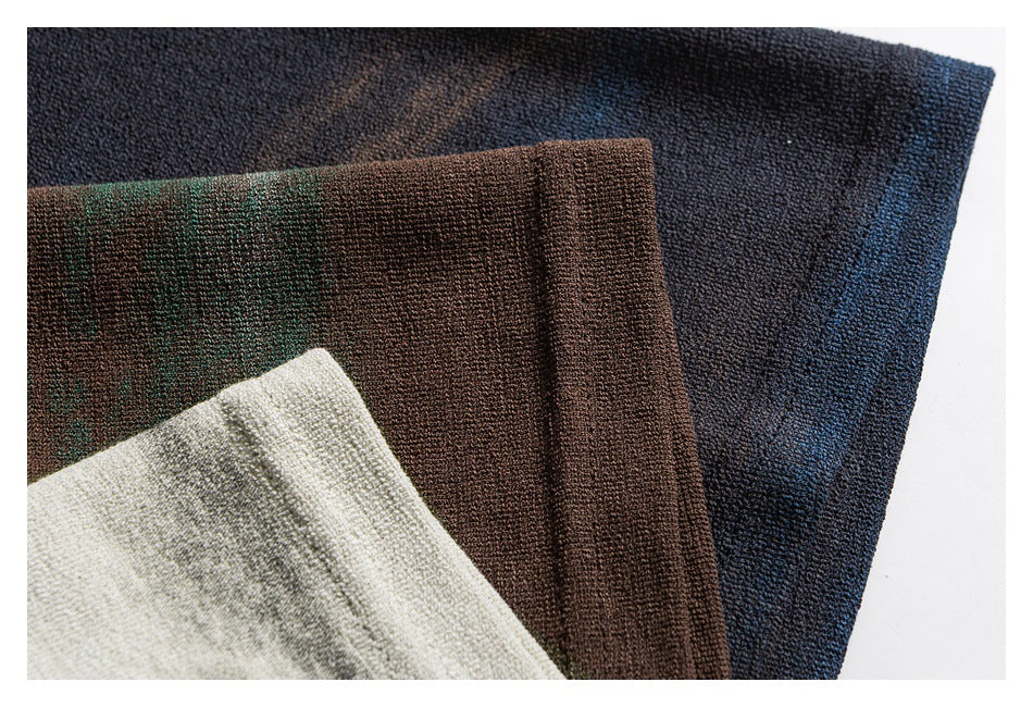 Close-up of textured shirt fabric in navy-blue, brown-green, and ivory-gray colorways.