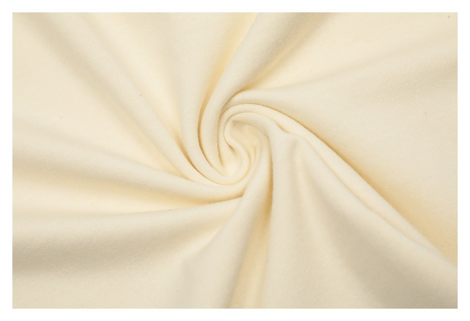 Close-up of soft-looking cream fabric gathered into a spiral fold.